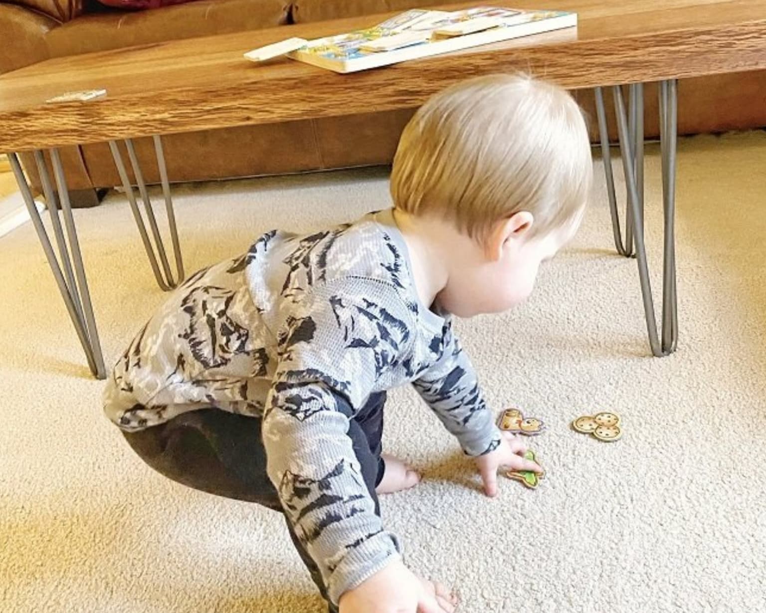 Toddler crawling on freshly cleaned cream carpet under a coffee table in a Dentsville, SC home